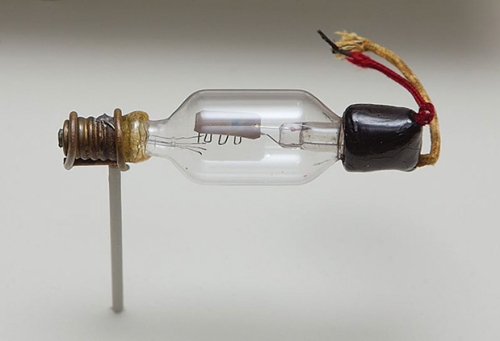 Hậu duệ của bóng đèn sợi đốt: Các ống chân không là một biến thể của các bóng đèn sợi đốt thông thường, được phát triển dựa trên nghiên cứu của Thomas Edison về khả năng phát electron của các dây tóc bóng đèn. Chẳng hạn như ống Audion thế hệ đầu, chế tạo năm 1906, trong hình trên trông rất giống một cái bóng đèn cho dù ta không thấy dây tóc đâu do nó đã bị cháy từ lâu. Sợi dây tóc đó, trước đây, đóng vai trò như một cực âm (cathode) mà từ đó các electron bay tới cực dương (anode) là một tấm kim loại nằm ở chính giữa của bóng thủy tinh. Dòng điện từ cực âm tới cực dương có thể được điều khiển bằng cách thay đổi điện áp trên lưới, là sợi dây dẫn chạy zigzag ở dưới tấm cực dương. Hình: Gregory Maxwell.